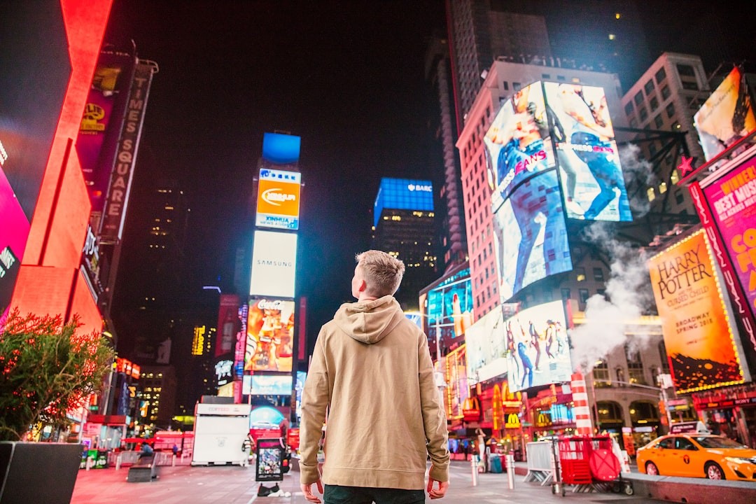 Hombre frente a Times Square observando publicidad digital